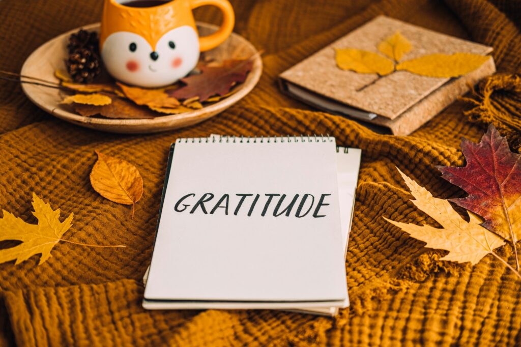 How to Practice Gratitude. Writing Autumn fall gratitude journal. Open paper notebook pages with