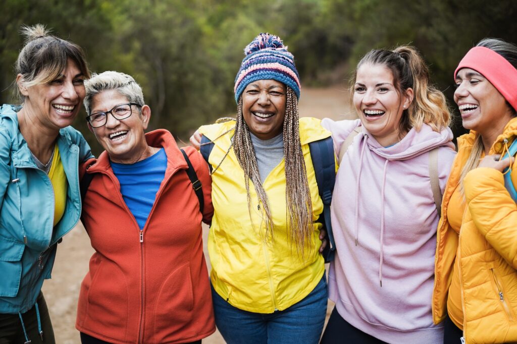 Multiracial women having fun during trekking day in to the wood